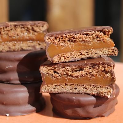 Alfajores bañados en chocolate rellenos de dulce de leche, partidos por la mitad